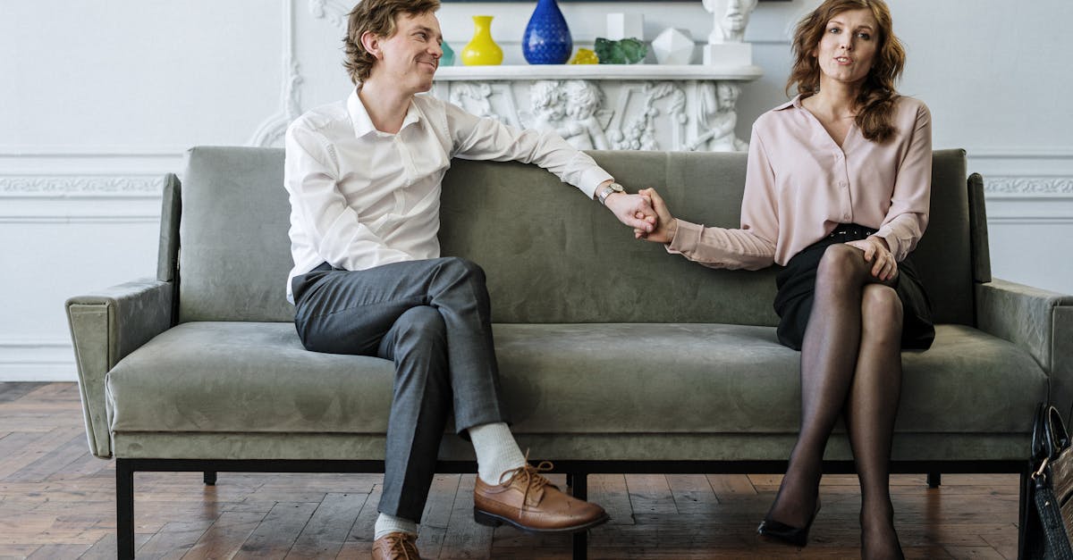 A couple in a therapy session holding hands, conveying support and connection.